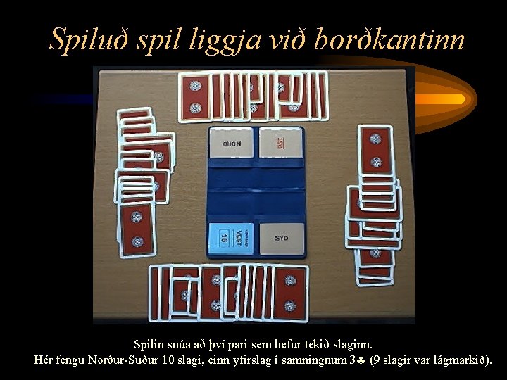 Spiluð spil liggja við borðkantinn Spilin snúa að því pari sem hefur tekið slaginn.