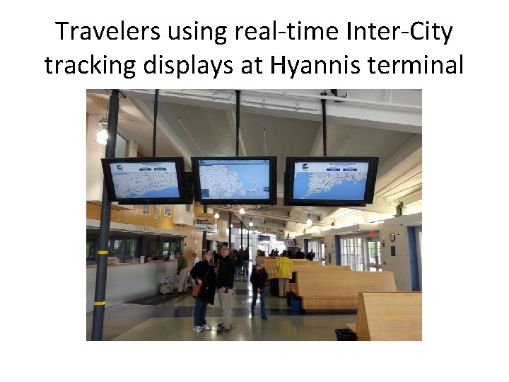 Travelers using real-time Inter-City tracking displays at Hyannis terminal 