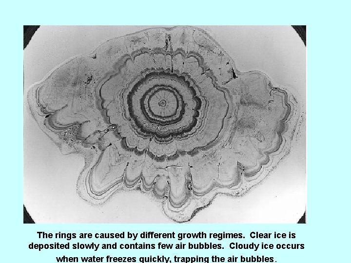 The rings are caused by different growth regimes. Clear ice is deposited slowly and