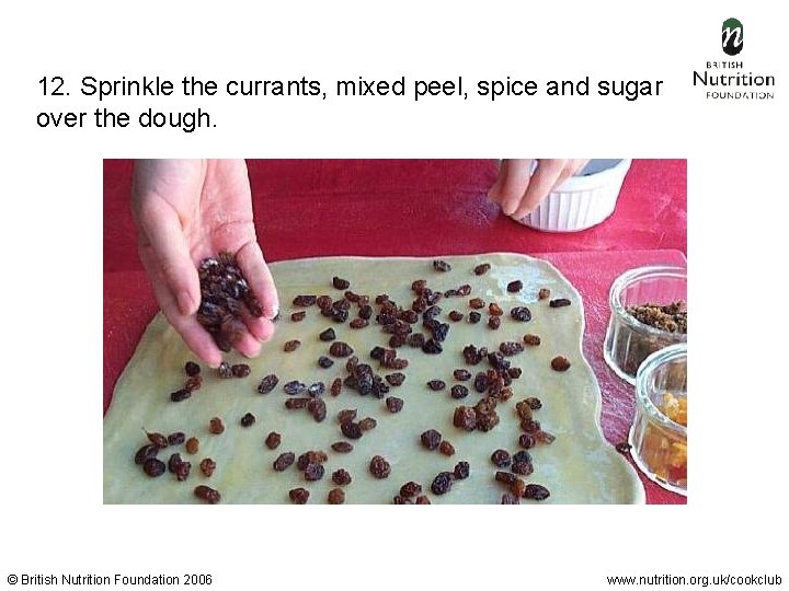 12. Sprinkle the currants, mixed peel, spice and sugar over the dough. © British