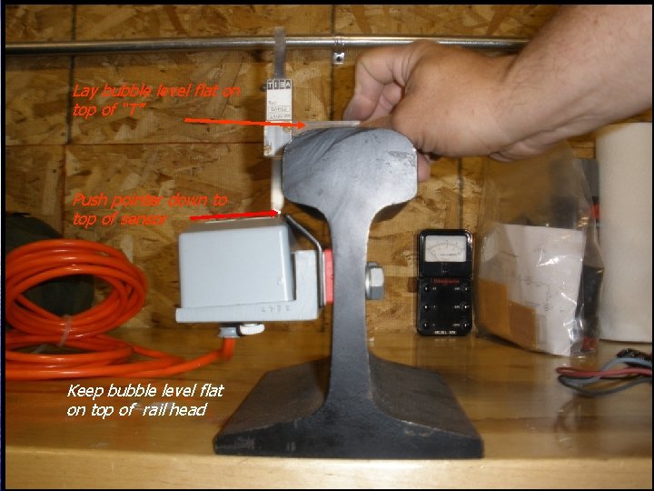 Lay bubble level flat on top of “T” Push pointer down to top of