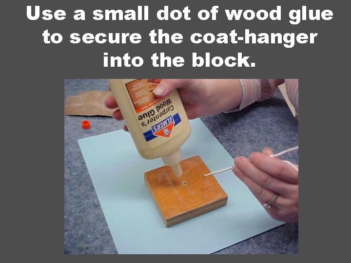 Use a small dot of wood glue to secure the coat-hanger into the block.