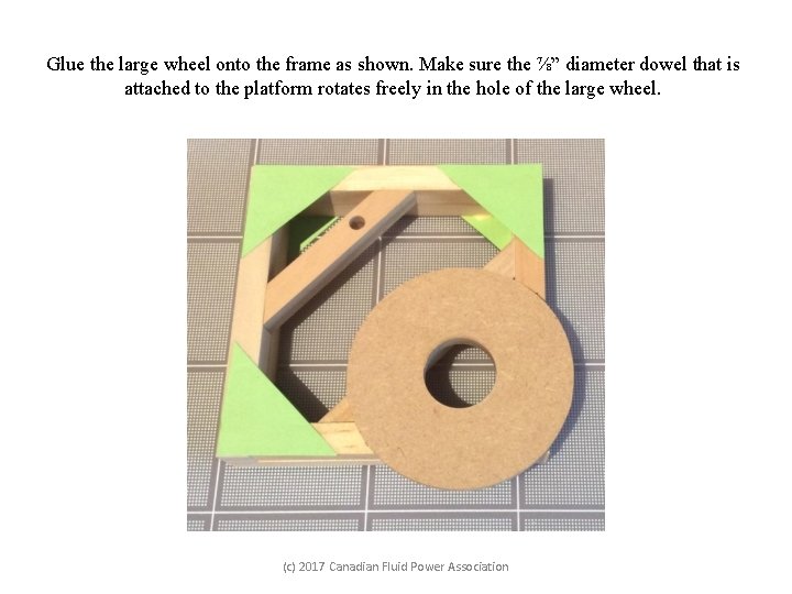 Glue the large wheel onto the frame as shown. Make sure the ⅞” diameter