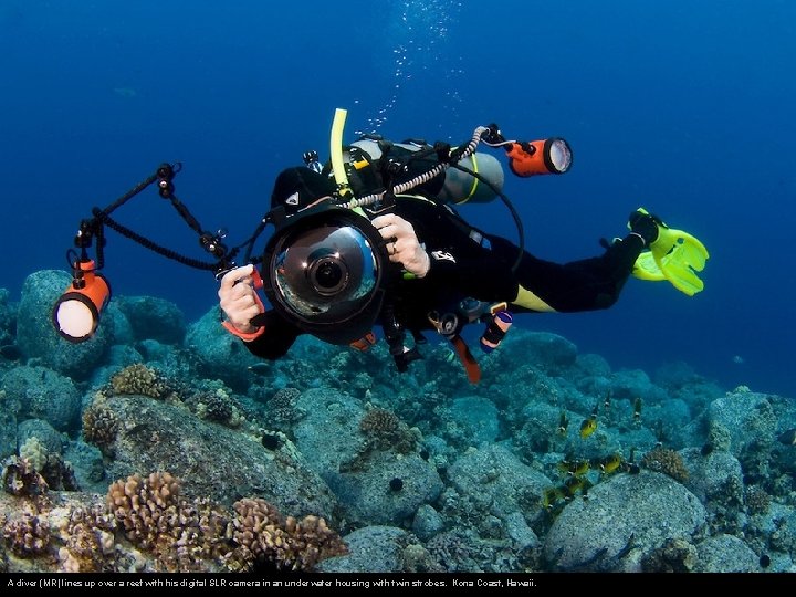 A diver (MR) lines up over a reef with his digital SLR camera in