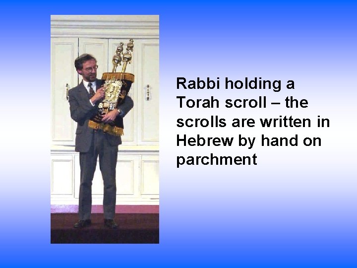 Rabbi holding a Torah scroll – the scrolls are written in Hebrew by hand