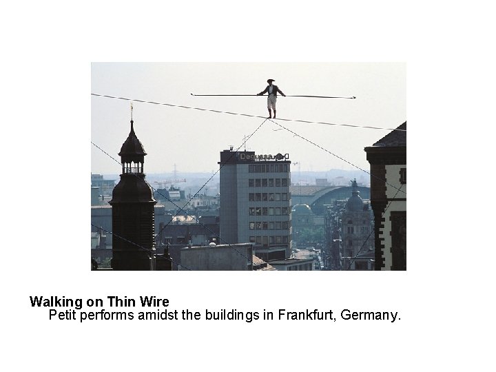 Walking on Thin Wire Petit performs amidst the buildings in Frankfurt, Germany. 