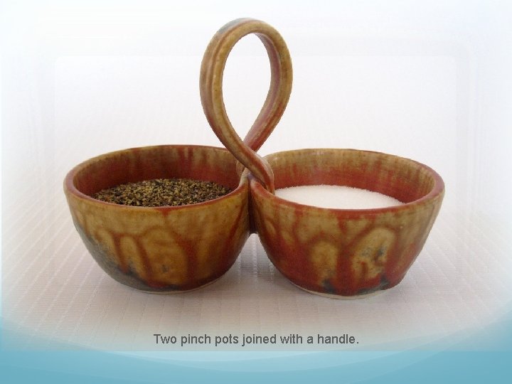 Two pinch pots joined with a handle. 