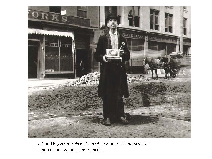 A blind beggar stands in the middle of a street and begs for someone