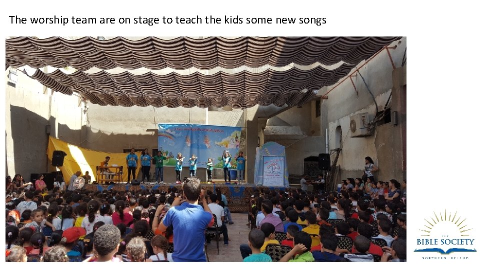 The worship team are on stage to teach the kids some new songs 