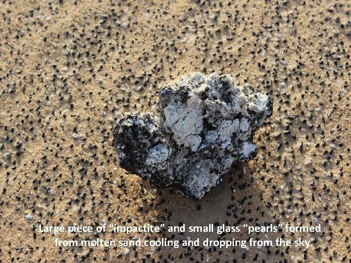 Large piece of “impactite” and small glass “pearls” formed from molten sand cooling and