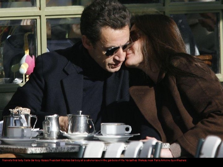 France's first lady Carla Sarkozy kisses President Nicolas Sarkozy at a cafe terrace in