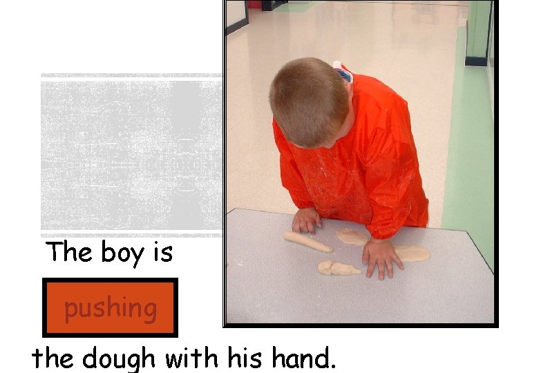 The boy is pushing the dough with his hand. 