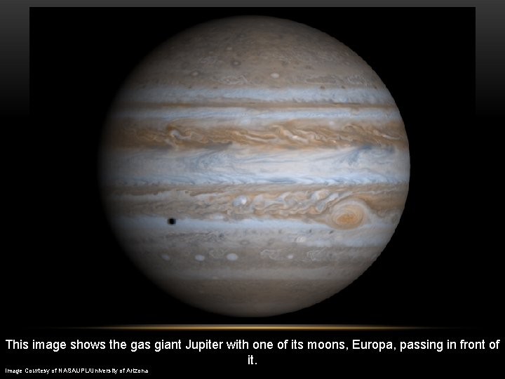 This image shows the gas giant Jupiter with one of its moons, Europa, passing