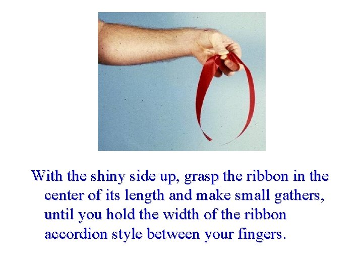 With the shiny side up, grasp the ribbon in the center of its length