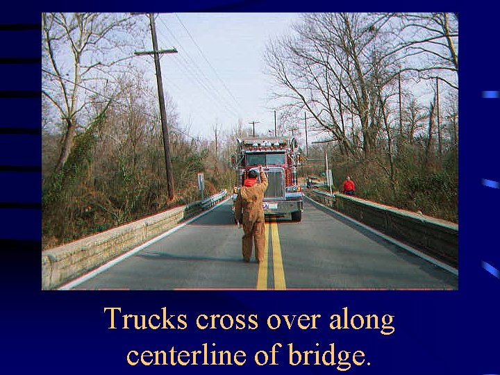 Trucks cross over along centerline of bridge. 