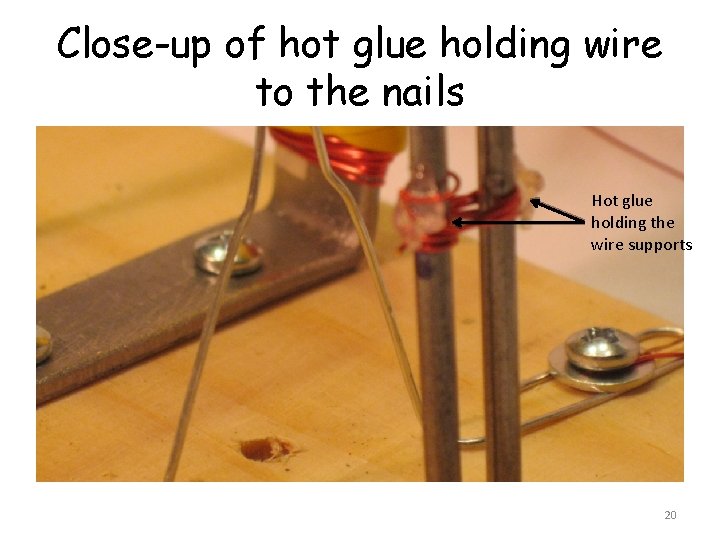 Close-up of hot glue holding wire to the nails Hot glue holding the wire