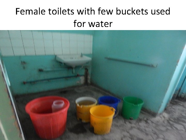 Female toilets with few buckets used for water 