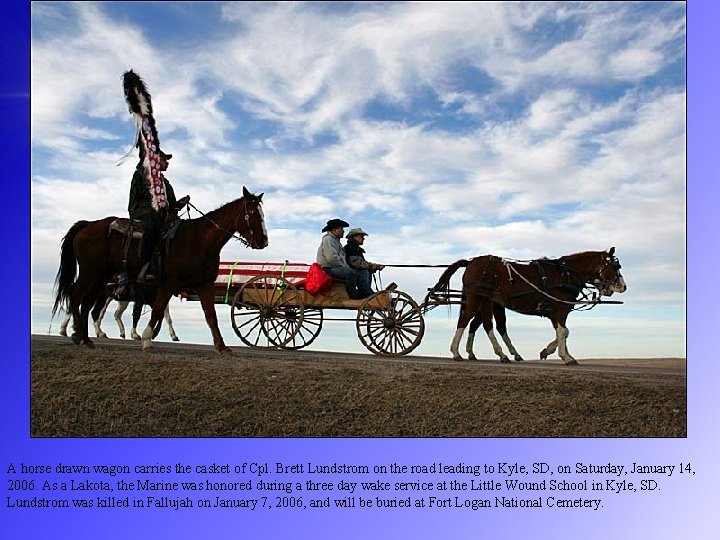 A horse drawn wagon carries the casket of Cpl. Brett Lundstrom on the road
