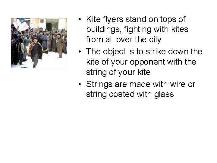  • Kite flyers stand on tops of buildings, fighting with kites from all