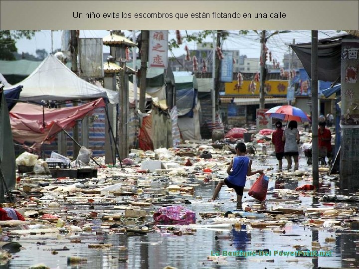 Un niño evita los escombros que están flotando en una calle La Boutique Del