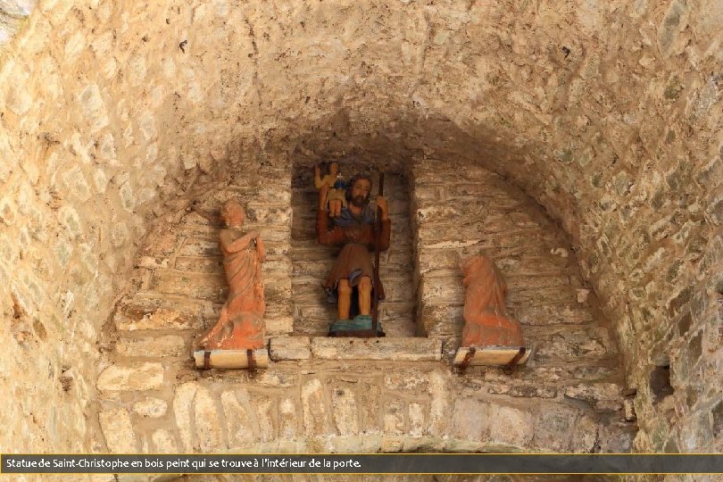 Statue de Saint-Christophe en bois peint qui se trouve à l'intérieur de la porte.