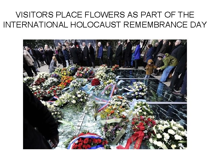 VISITORS PLACE FLOWERS AS PART OF THE INTERNATIONAL HOLOCAUST REMEMBRANCE DAY 