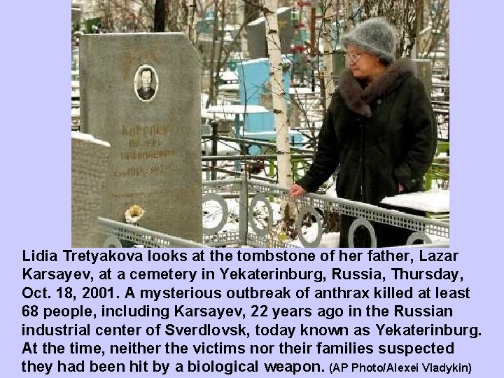 Lidia Tretyakova looks at the tombstone of her father, Lazar Karsayev, at a cemetery
