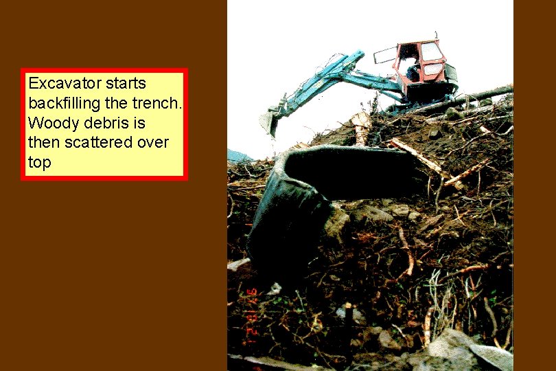 Excavator starts backfilling the trench. Woody debris is then scattered over top 