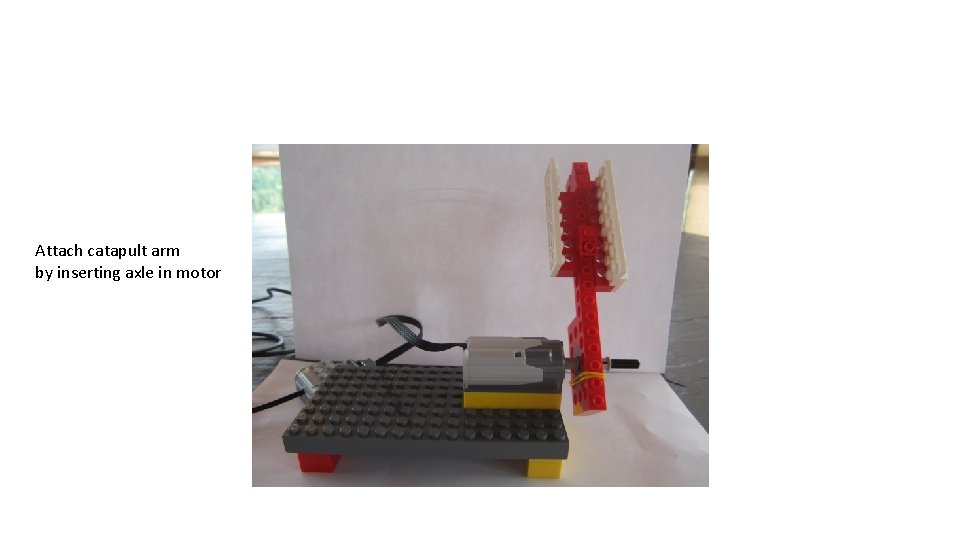 Attach catapult arm by inserting axle in motor 