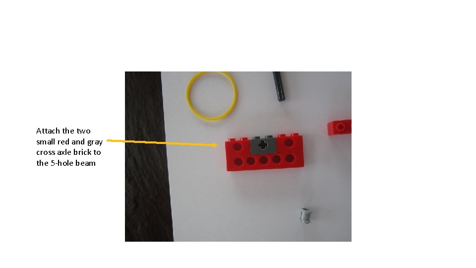 Attach the two small red and gray cross axle brick to the 5 -hole