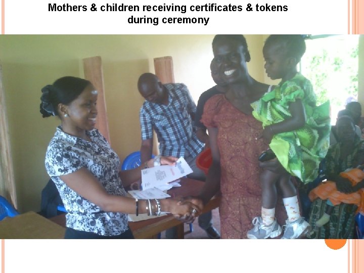 Mothers & children receiving certificates & tokens during ceremony 