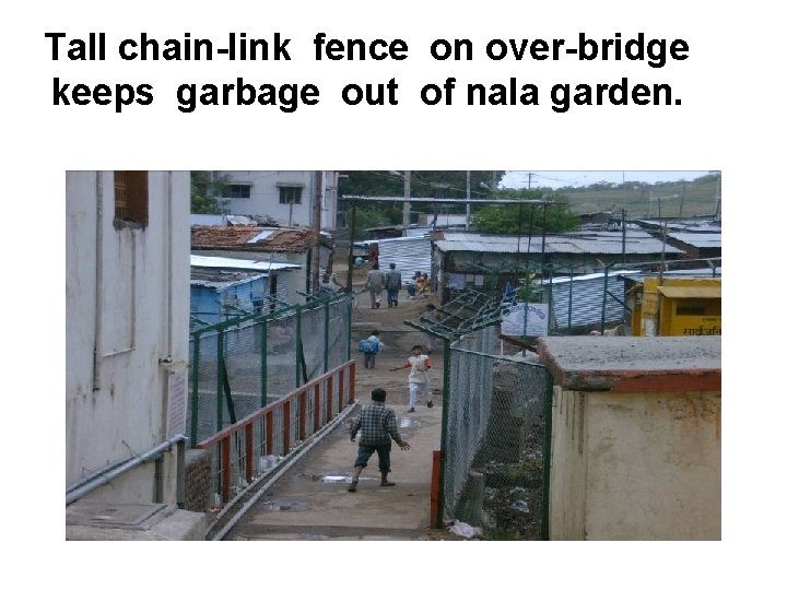 Tall chain-link fence on over-bridge keeps garbage out of nala garden. 