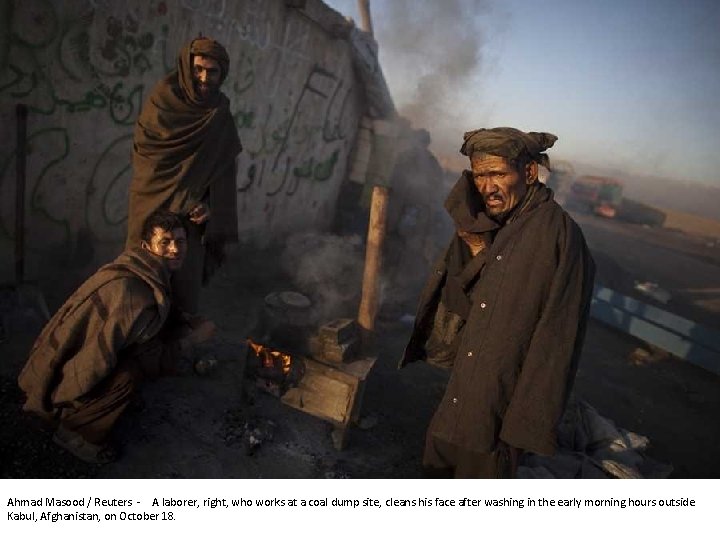 Ahmad Masood / Reuters - A laborer, right, who works at a coal dump