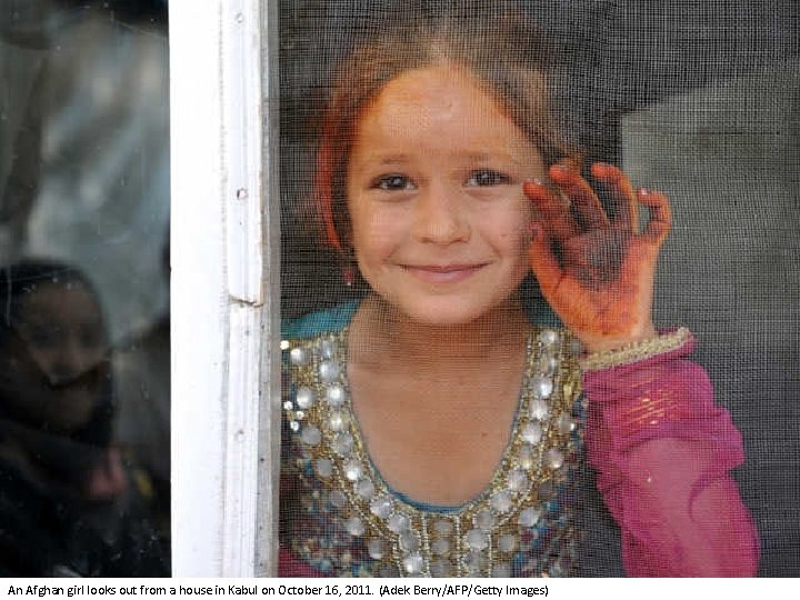 An Afghan girl looks out from a house in Kabul on October 16, 2011.