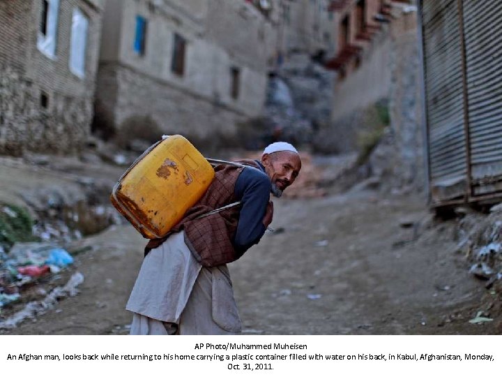 AP Photo/Muhammed Muheisen An Afghan man, looks back while returning to his home carrying