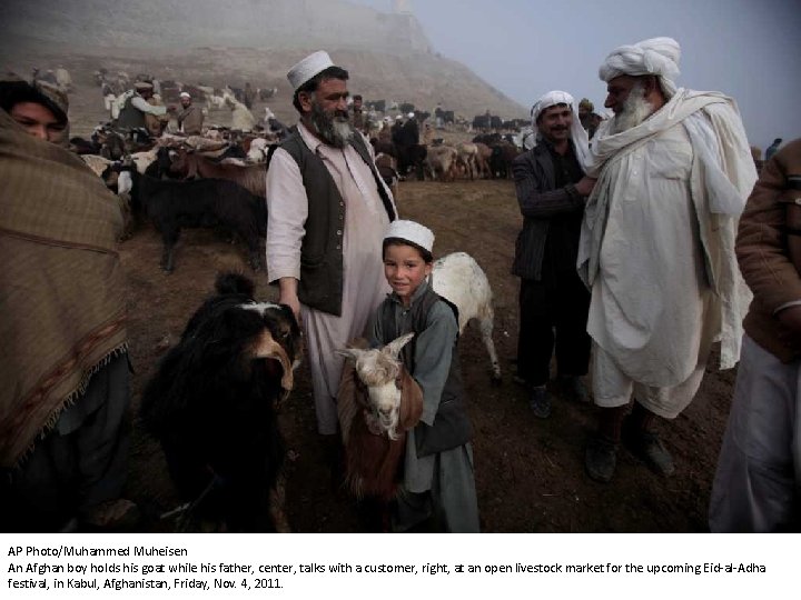 AP Photo/Muhammed Muheisen An Afghan boy holds his goat while his father, center, talks