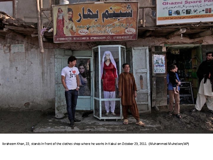 Ibraheem Khan, 22, stands in front of the clothes shop where he works in