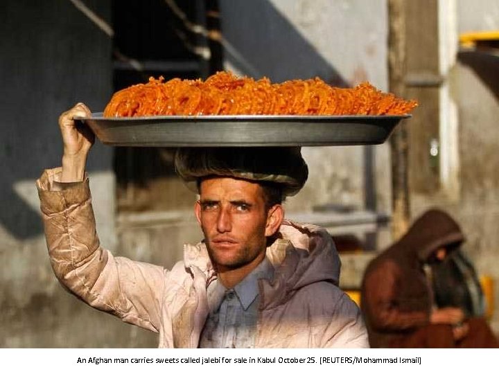 An Afghan man carries sweets called jalebi for sale in Kabul October 25. [REUTERS/Mohammad