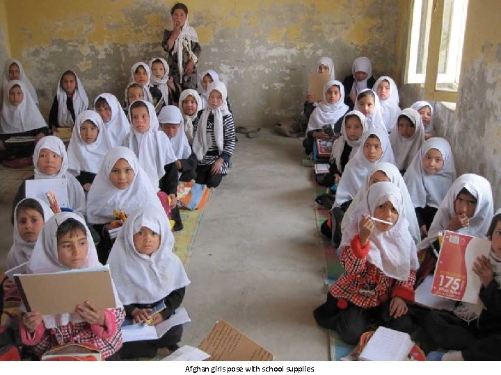 Afghan girls pose with school supplies. 