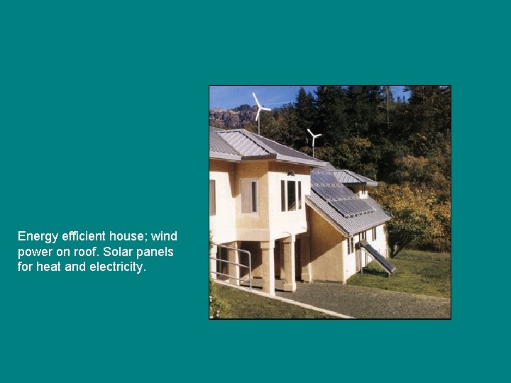 Energy efficient house; wind power on roof. Solar panels for heat and electricity. 
