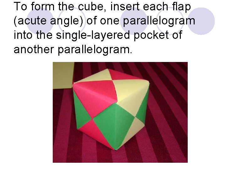 To form the cube, insert each flap (acute angle) of one parallelogram into the