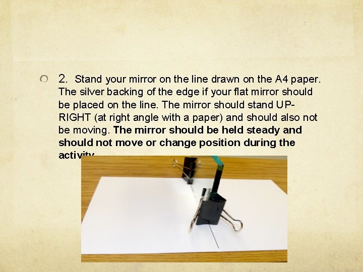 2. Stand your mirror on the line drawn on the A 4 paper. The