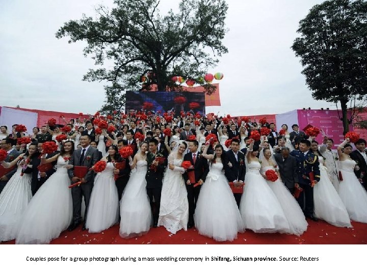 Couples pose for a group photograph during a mass wedding ceremony in Shifang, Sichuan