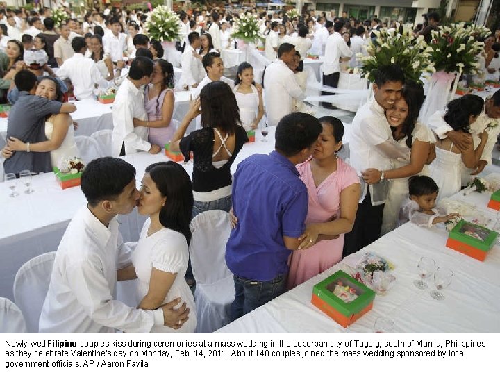 Newly-wed Filipino couples kiss during ceremonies at a mass wedding in the suburban city