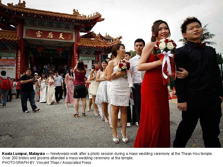 Kuala Lumpur, Malaysia — Newlyweds walk after a photo session during a mass wedding