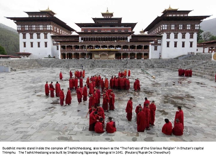 Buddhist monks stand inside the complex of Tashichhodzong, also known as the "The Fortress