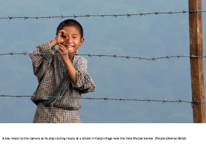 A boy reacts to the camera as he plays during recess at a school