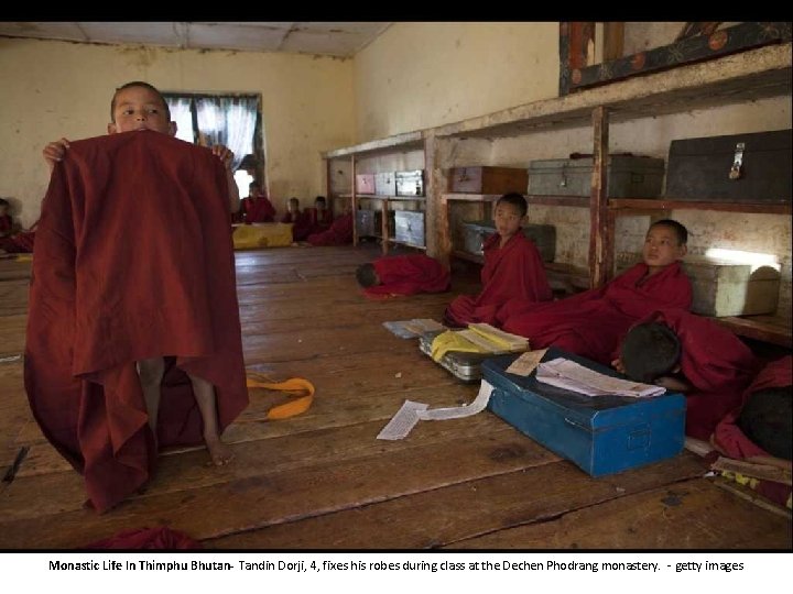 Monastic Life In Thimphu Bhutan- Tandin Dorji, 4, fixes his robes during class at