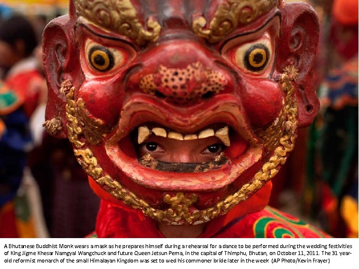 A Bhutanese Buddhist Monk wears a mask as he prepares himself during a rehearsal