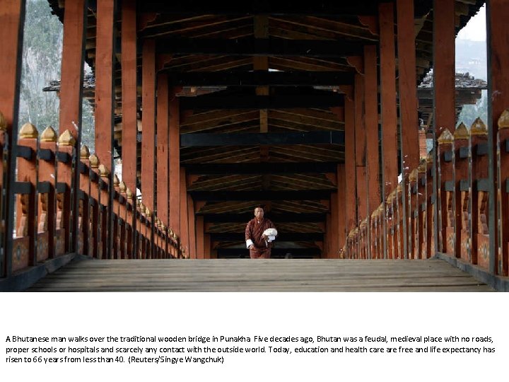 A Bhutanese man walks over the traditional wooden bridge in Punakha. Five decades ago,